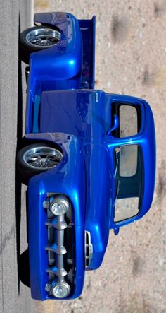 an overhead view of a blue truck parked on the side of a road in front of a building