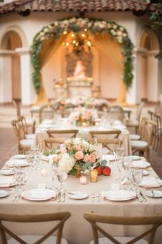 a table set up with white and pink flowers