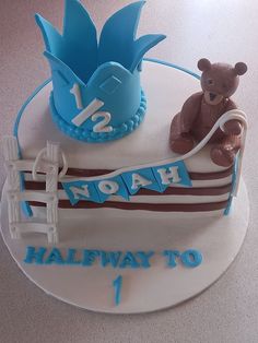 a birthday cake with a teddy bear sitting on top of it and the number one