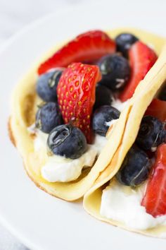 two crepes with strawberries and blueberries on them