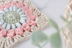 a crocheted dishcloth is sitting on a table next to a pot holder