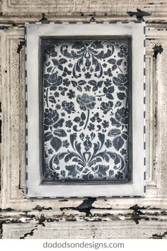 an old wooden frame with black and white wallpaper