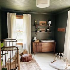 a baby's room with a crib, dresser and bed in it that has white drapes on the windows