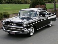 an old black and white car parked on the street