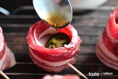 a spoon scooping some food out of an open pita bread on a grill