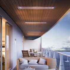 a balcony with couches and chairs overlooking the ocean