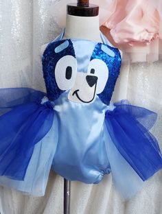 a blue and white teddy bear on top of a mannequin headdress