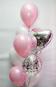 balloons and confetti are arranged in a vase