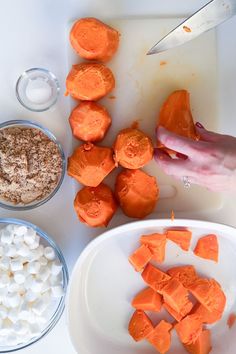 carrots, marshmallows, and other ingredients on a cutting board next to a knife