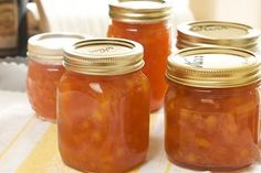 four jars filled with food sitting on top of a table