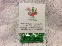 green candy candies are in a package on a lace tablecloth with the message grinch poop