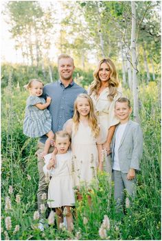 a family posing for a photo in the woods