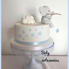 there is a white cake with blue stars on it and an elephant figurine