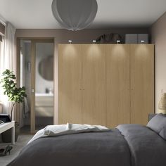 a bed sitting next to a wooden cabinet in a bedroom