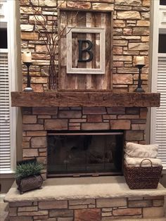 a stone fireplace with a sign above it that says b on the mantle and candles