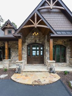 the front entrance to a home with stone and wood trimmings on the side