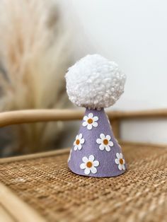 a small purple hat with white flowers on it