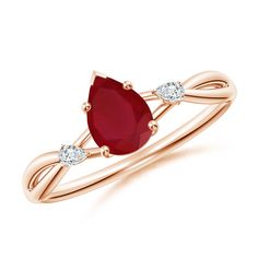 a rose gold ring with a pear shaped ruby stone and two diamonds on the band