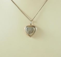 A delightful vintage sterling silver heart shaped double locket for four photographs.  The front engraved with a flower and stylized foliage opening to reveal space for two photographs, no frames or glass. The plain reverse opening to the side to reveal space for two photographs, also no frames or glass. Marked within "925" for sterling silver only. The chain is for display only. Probably Germany 1970s. 6.2g The small photographs 1cm x 1cm.  In inches 2/8". The larger photographs 1.5cm x 1.5cm.  In inches 1/2". The locket 2.1cm x 2cm.  In inches 3/4". With bail 2.9cm.  In inches 1 1/8". IN GOOD VINTAGE CONDITION WITH A TINY HOLE TO THE LOWER FRONT: NO FRAMES OR GLASS INTENDED: In good antique condition with a tiny hole to the lower front. Needing another good polish. No frames or glass int Vintage Hallmarked White Gold Locket Necklace, Silver Double Heart Locket Necklace, Silver Heart Locket Necklace For Anniversary, Heart-shaped Hallmarked Locket Necklace For Weddings, Vintage Locket Necklace With Polished Finish For Anniversary, Hallmarked Heart Locket Necklace For Wedding, Heart Shaped Hallmarked Locket Necklace For Wedding, Heart-shaped White Gold Locket Necklace For Memorial, Vintage Stamped 925 Jewelry Keepsake