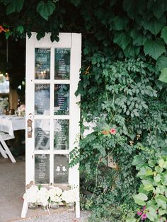 an old door is covered with greenery in front of a table