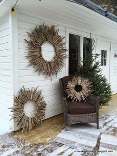 two sunburst wreaths on the side of a white house next to a chair