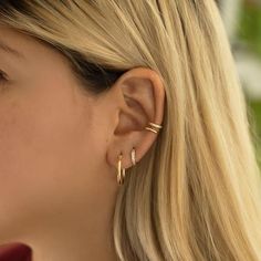 a close up of a person wearing earrings and looking at the side of her face