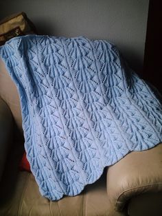 a blue blanket sitting on top of a couch