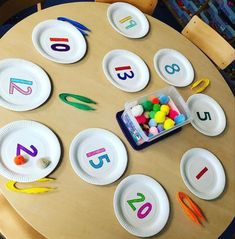 the table has paper plates with numbers on them and plastic candy in front of it