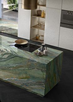 a modern kitchen with green marble counter tops