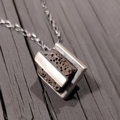 Sterling Silver pendant magically holding a volcanic cube. Oxidized Sterling Silver curb chain(all pics) or silver links chain(5th pic). The Lava cube is approx. 11mm*11mm. 8th pic - right side - same same but from Brass :  https://www.etsy.com/listing Unisex. More Lava jewelry :  https://www.etsy.com/shop/galbarash?ref=listing-shop2-all-items-count&search_query=Lava For more pendants and necklaces :  https://www.etsy.com/shop/galbarash?section_id=6177780&ref=shopsection_leftnav_2 Back to my sho Square Stone Pendant, Math Jewelry, Hex Ring, Lava Stone Jewelry, Lava Jewelry, Jewelry Design Studio, Hexagonal Ring, Silver Link Chain, Square Stone