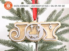 a wooden ornament hanging from a christmas tree with the word joy on it