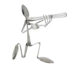 a metal figurine holding a knife and fork in the air with one hand