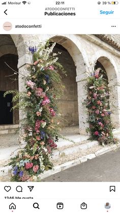 an arch covered in flowers next to a building