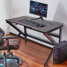 a computer desk with a gaming chair next to it and a monitor on the table