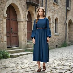 The simplicity of this modern, classic blue dress exudes elegance. The dress has a flattering boat neckline with gracefully gathered sleeves that accentuate one's natural silhouette. The length of the dress is at midi length, providing a sophisticated and versatile look that can suit casual and formal events alike. A slim brown belt at the waist cinched in adds just a touch of accent and nice fit. Every gown is carefully hand-made under the supervision of skillful workers, which ensures that the Blue Dress For Women, Blue Dresses For Women, Belted Tunic, Boho Festival Outfit, Designer Image, Suit Casual, Bohemian Mode, Marine Uniform, Mode Boho