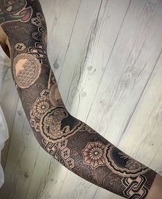 a man's arm with an intricate tattoo design on the arm and arms,