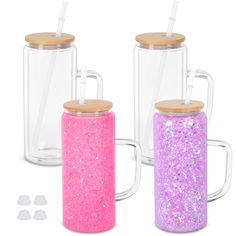 three glass mugs with wooden lids and straw in the bottom one is filled with glitter