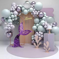 a purple and silver balloon arch with balloons