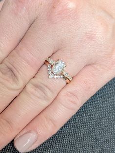 a close up of a person's hand with a diamond ring on their finger