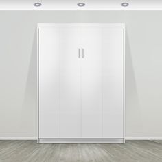 an empty room with white cupboards and wooden flooring on the walls, in front of a gray wall