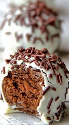 two chocolate donuts with white frosting and sprinkles on the top