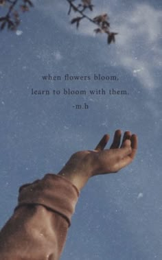 a person's hand reaching up into the sky with a quote above it that reads, when flowers bloom, learn to bloom with them