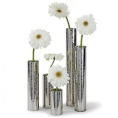 four silver vases with white flowers in them