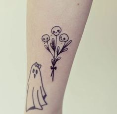 a person with a tattoo on their leg that is decorated with skulls and flowers in the shape of a ghost