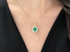 Featured here is a stunning oval cut Colombian emerald and diamond pendant made in fine 18K yellow gold. Displayed is a lustrous, grassy green with incredible transparency, accented by a simple four-prong 18K mount, allowing for the emerald to be shown in full view. Minor flaws are evident in this earth mined gem as no natural emerald is perfect. A brilliant round diamond halo surrounds the emerald and is a showstopping compliment to the center gem! This piece is ideal for everyday wear or for s Exquisite Oval Emerald Necklace, Elegant Oval Emerald Necklace In Yellow Gold, Luxury Oval Emerald Necklace With Brilliant Cut, Luxury Oval Emerald Necklace For Anniversary, Exquisite Yellow Gold Oval Emerald Necklace, Oval Brilliant Cut Emerald Necklace For Anniversary, Emerald Anniversary, Round Diamond Halo, Halo Pendant