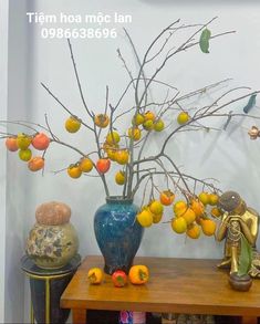 there is a vase with oranges in it on the table next to other items