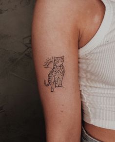 a woman's arm with a small tattoo of a cat on the left side of her arm