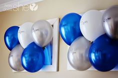 blue and silver balloons are hanging on the wall