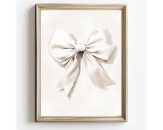 a white bow hanging on the wall above a framed art print in a gold frame