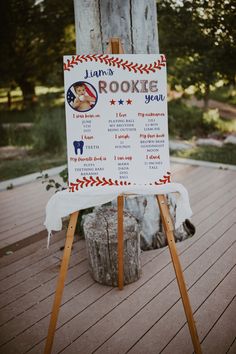 a sign that is sitting on top of a wooden stand in front of a tree